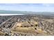 Aerial view of a residential neighborhood with nearby park, field, and distant mountains at 4621 S Perry Way, Denver, CO 80236