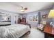 A relaxing bedroom featuring a ceiling fan and a large window with natural light at 4621 S Perry Way, Denver, CO 80236