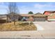 A brick home featuring a two-car garage, landscaped front yard, and a driveway at 4621 S Perry Way, Denver, CO 80236