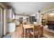 Open kitchen and dining area with white cabinets, stainless steel appliances, and natural light at 4621 S Perry Way, Denver, CO 80236