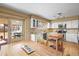 Bright kitchen and dining area with white cabinets, stainless steel appliances, and outdoor access at 4621 S Perry Way, Denver, CO 80236