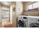 Bright laundry room with LG washer and dryer and built-in shelving, next to the kitchen at 4621 S Perry Way, Denver, CO 80236