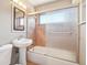 Cozy bathroom featuring a bathtub with glass doors and a pedestal sink at 3580 Locust St, Denver, CO 80207