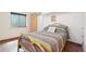 Cozy bedroom features earth tone colors, a warm gold bedframe, and a window letting in natural light at 3580 Locust St, Denver, CO 80207