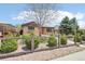 Brick home featuring a fenced yard with lush greenery, mature trees, and a stone walkway at 3580 Locust St, Denver, CO 80207