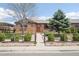 Beautiful brick home with landscaped front yard, mature trees, and charming fenced garden at 3580 Locust St, Denver, CO 80207