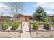 Charming brick home featuring a fenced yard with lush greenery, mature trees, and inviting pathway at 3580 Locust St, Denver, CO 80207