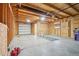 Open unfinished garage with a concrete floor, wooden beam framing and a new overhead door at 3580 Locust St, Denver, CO 80207