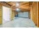 Spacious unfinished garage features wooden beam framing, concrete floor and a large garage door at 3580 Locust St, Denver, CO 80207