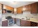 Kitchen featuring stainless steel appliances, wood cabinets, and neutral countertops at 3580 Locust St, Denver, CO 80207