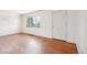 Living room with hardwood floors, white walls, window, and white door at 3580 Locust St, Denver, CO 80207