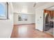 Open floor plan with a large window, hardwood floors, and stainless appliances in kitchen at 3580 Locust St, Denver, CO 80207
