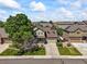 An aerial shot of a well-maintained two-story home with a landscaped yard, driveway, and a backdrop of neighborhood houses at 13445 Kearney St, Thornton, CO 80602