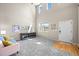 A bright living room with high ceilings, large windows, and carpeted floors offers a welcoming entrance at 13445 Kearney St, Thornton, CO 80602