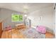 Bright room featuring hardwood floors, large window, colorful rug, seating and a bookshelf at 13445 Kearney St, Thornton, CO 80602