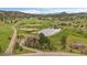 Stunning aerial view of home, pond and lush green land at 7082 Silverhorn Dr, Evergreen, CO 80439