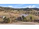 Wide aerial shot of beautiful acreage with a pond and home with solar panels at 7082 Silverhorn Dr, Evergreen, CO 80439