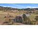 Aerial view of the beautiful home with a pond in the distance, surrounded by nature at 7082 Silverhorn Dr, Evergreen, CO 80439