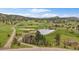 Stunning aerial view of home on acreage with pond, trees and mountain views at 7082 Silverhorn Dr, Evergreen, CO 80439