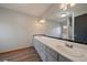 Bathroom with a double sink vanity, modern fixtures, and a large mirror at 7082 Silverhorn Dr, Evergreen, CO 80439