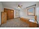A cozy bedroom with carpet flooring features a ceiling fan, closet, and two windows with blinds for natural light at 7082 Silverhorn Dr, Evergreen, CO 80439