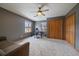 Spacious bedroom with carpeted floors, two windows, a ceiling fan, and closet space for storage at 7082 Silverhorn Dr, Evergreen, CO 80439