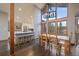 Open-concept dining area with modern chandelier and large windows with outside view at 7082 Silverhorn Dr, Evergreen, CO 80439