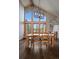Stylish dining area with a wooden table, modern chandelier, and large windows at 7082 Silverhorn Dr, Evergreen, CO 80439