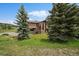 Exterior elevation featuring a stone facade and mature trees at 7082 Silverhorn Dr, Evergreen, CO 80439