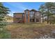 Charming brown two-story home featuring a stone chimney and large windows at 7082 Silverhorn Dr, Evergreen, CO 80439