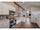 Open kitchen with stainless steel appliances, island, and view of the living area with a fireplace at 7082 Silverhorn Dr, Evergreen, CO 80439