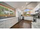 Well-lit kitchen with white cabinets, stainless steel appliances, granite countertops, and hardwood floors at 7082 Silverhorn Dr, Evergreen, CO 80439