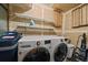 Bright laundry room featuring a full sized washer and dryer and shelving for storage at 7082 Silverhorn Dr, Evergreen, CO 80439