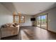 Comfortable living room with hardwood floors, a cozy couch, and large windows showcasing the beautiful outdoor view at 7082 Silverhorn Dr, Evergreen, CO 80439