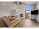Bright living room with hardwood floors, stone fireplace, and large windows with scenic views at 7082 Silverhorn Dr, Evergreen, CO 80439