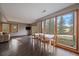 Open-concept living area with hardwood floors and large windows showcasing the beautiful outdoor view at 7082 Silverhorn Dr, Evergreen, CO 80439