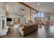 Spacious living area flowing into the kitchen, featuring a fireplace and hardwood floors at 7082 Silverhorn Dr, Evergreen, CO 80439