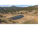 Scenic aerial view of the pond surrounded by a well-manicured landscape and tree coverage at 7082 Silverhorn Dr, Evergreen, CO 80439