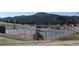 Well-maintained tennis court with scenic views of the surrounding wooded landscape at 7082 Silverhorn Dr, Evergreen, CO 80439