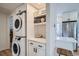 Laundry area with stacked washer and dryer, built-in shelving, and a view of the kitchen at 1010 S Newton St, Denver, CO 80219