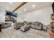 Open living room with neutral-toned furniture, wood-look flooring, and rustic beam at 14867 E Pacific Pl, Aurora, CO 80014