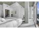 Spacious bedroom featuring an en-suite bathroom, city views, and a sleek white bed at 1700 Bassett St # 1301, Denver, CO 80202