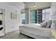 Bright bedroom featuring city views through large windows and a sleek white bed at 1700 Bassett St # 1301, Denver, CO 80202
