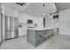Bright kitchen with gray island, white cabinets, stainless steel appliances, and clear seating at the island at 1700 Bassett St # 1301, Denver, CO 80202