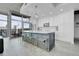 Bright modern kitchen featuring a gray island with seating, white cabinets, and large windows with city views at 1700 Bassett St # 1301, Denver, CO 80202