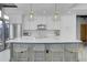 Bright kitchen with gray island, white cabinets, stainless appliances, and clear acrylic and gold seating at 1700 Bassett St # 1301, Denver, CO 80202