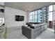 Modern living room with sleek gray sofa, brick accent wall, and large windows showcasing city views at 1700 Bassett St # 1301, Denver, CO 80202