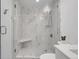 Bright shower featuring a marble tiled shower with glass doors, a shower bench, and chrome fixtures at 1700 Bassett St # 1301, Denver, CO 80202