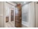 Bright bathroom featuring a tub shower, tile surround, and wood cabinets and doors at 670 Portland Rd, Monument, CO 80132
