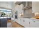 Bright kitchen featuring white cabinets, stainless appliances, granite counters, and a view into the living room at 670 Portland Rd, Monument, CO 80132